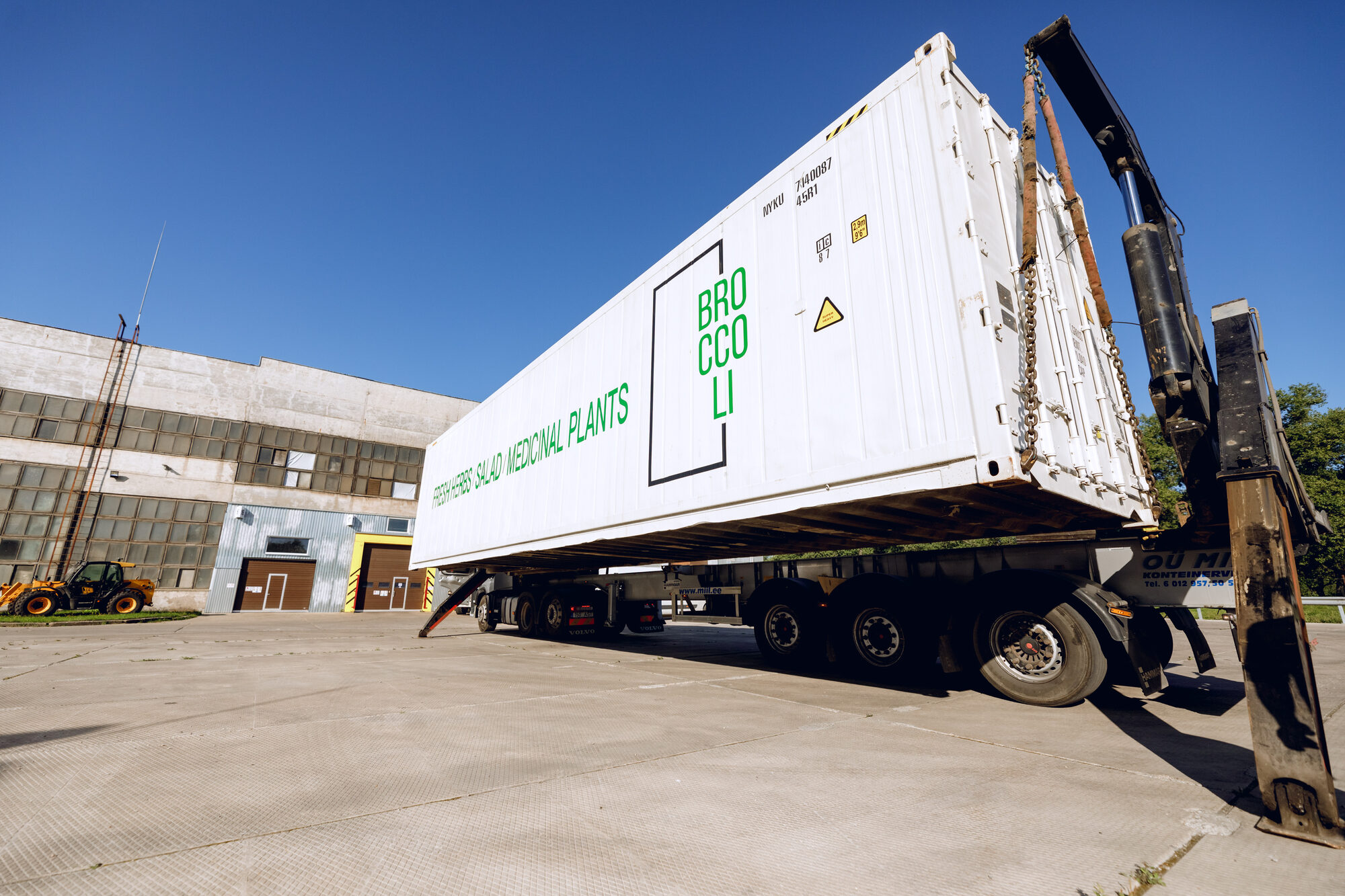Container lifted by crane onto a truck